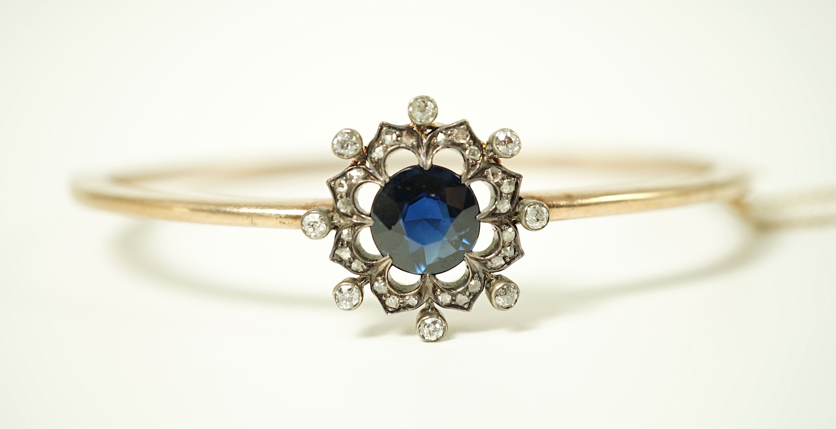 A Victorian gold, sapphire and diamond cluster set hinged bangle